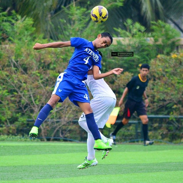 full length, lifestyles, leisure activity, mid-air, childhood, grass, boys, sport, casual clothing, playing, fun, skill, jumping, enjoyment, playful, elementary age, field, tree