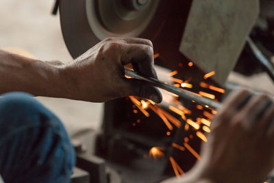 Cropped hands of worker working in factory