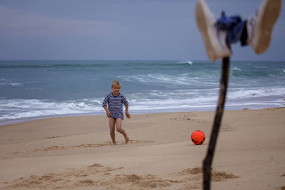 Rear view of boy playing at beach