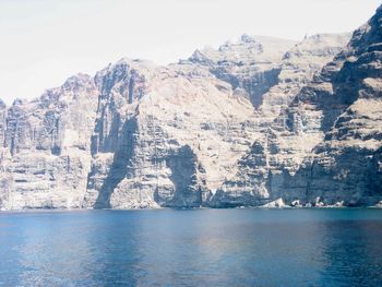 Scenic view of sea and mountains against sky