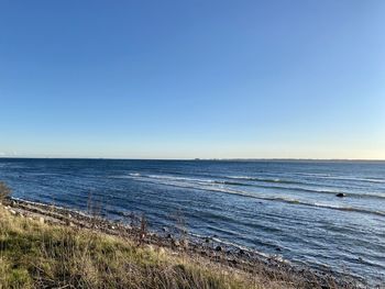 Scenic view of sea against clear blue sky