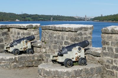 View of old cannons on shore against clear sky