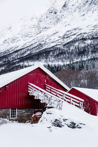 Built structure on snow covered houses by mountain