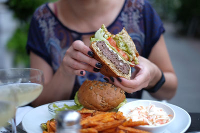 Midsection of woman having burger