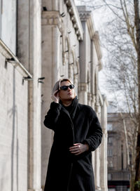 Young man wearing sunglasses standing in winter