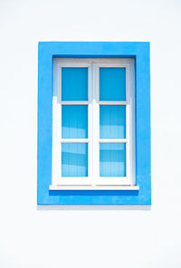 Blue window on white wall of building
