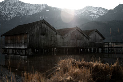 Stilt houses over lake against mountains