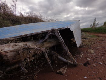 Abandoned wood on field against sky