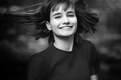 Portrait of smiling teenage girl with tousled hair 