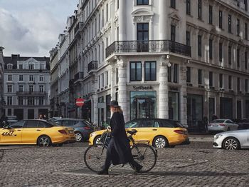 Vehicles on road by buildings in city