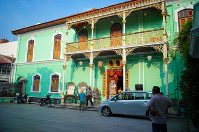 People on street against buildings in city