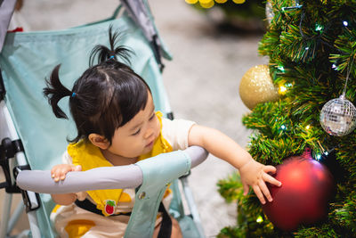 Cute baby girl touching christmas decoration