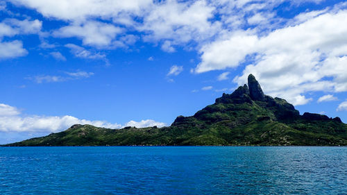 Scenic view of sea and mountains against sky