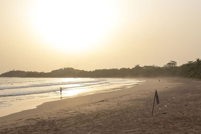 Scenic view of beach against clear sky during sunset