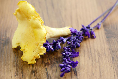 Golden chanterelle and flower on wooden table