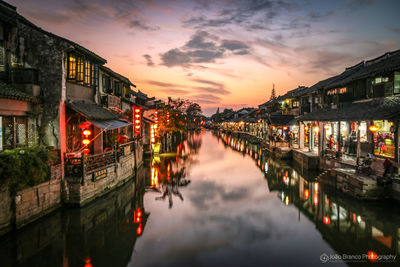 Panoramic view of illuminated city against sky at sunset