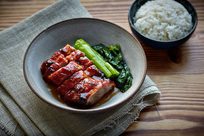 High angle view of barbecue pork with rice in bowl on table