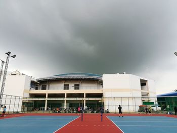 View of people playing in front of built structure