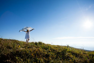 Rear view of person standing on field against clear sky