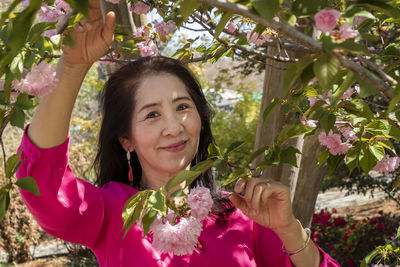 Portrait of a smiling young woman with pink flowers