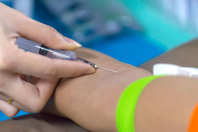 Cropped hand of doctor injecting patient in hospital