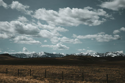 Scenic view of field and mountains against sky