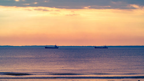 Scenic view of sea against dramatic sky during sunset