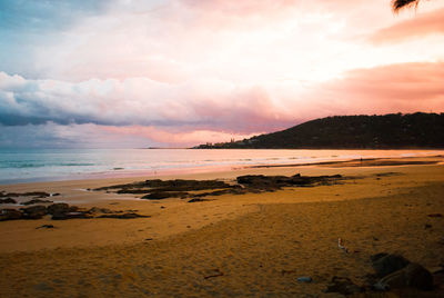 Scenic view of beach against sky during sunset