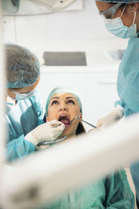 Female dentists examining patient at clinic