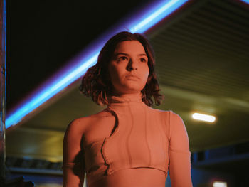 Portrait of woman standing against illuminated lights