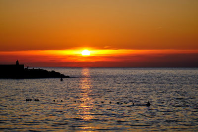 Scenic view of sea against orange sky