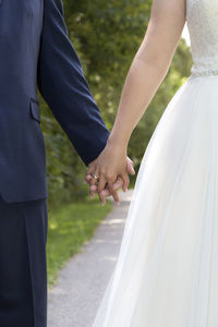 Midsection of bride holding bouquet