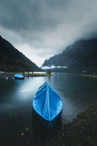 Scenic view of boat docked near shore. moody landscape with foggy mountains on the background