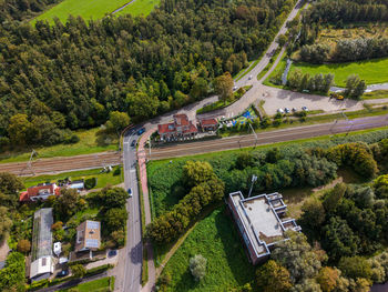 Aerial view of a semi rural area with a railway line, small station, parked cars, level crossing