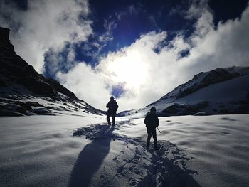 Tourists on mountain against sky