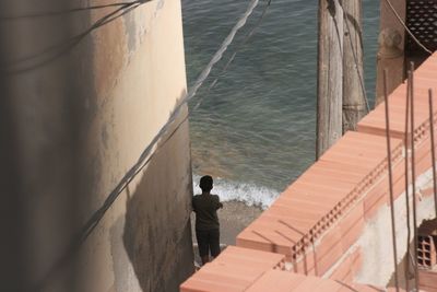 High angle view of man standing on retaining wall