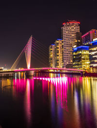 Illuminated bridge over river at night in manchester england,  salford quays  media city