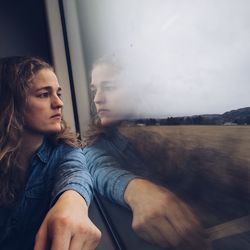 Portrait of young man looking at train window
