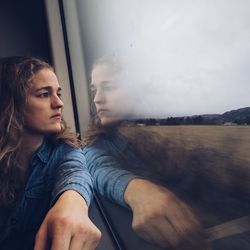 Woman looking through window on train