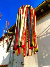 Low angle view of hanging lights against clear blue sky