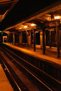 Illuminated railroad station platform at night