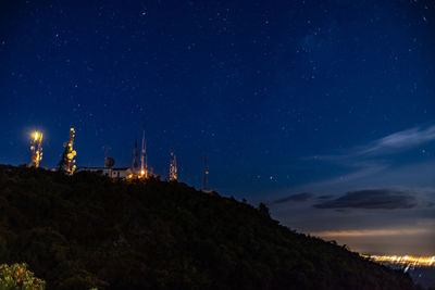 Low angle view of illuminated lights against sky at night