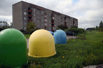 Multi colored balloons on field against sky in city