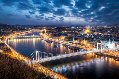 Bridge over river against cloudy sky