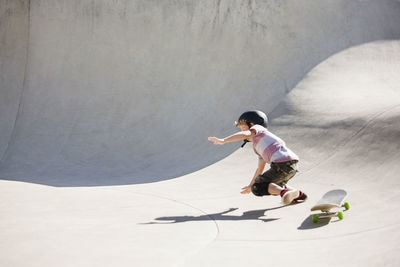 Boy falling on skateboard ramp