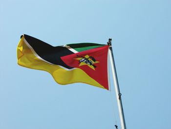 Low angle view of mozambique flag against clear sky