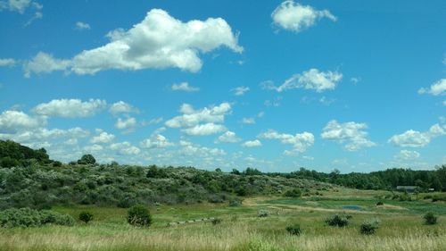 Scenic view of grassy field against cloudy sky