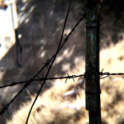 Low angle view of barbed wire fence against sky