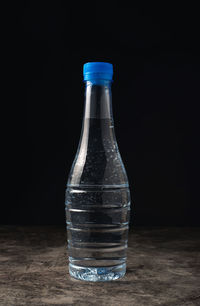 Close-up of glass bottle against black background