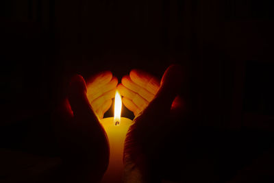 Close-up of lit candle in the dark